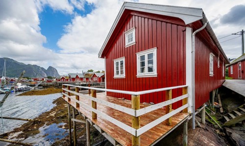 Rorbuer, typical red wooden house on the banks of Reinefjord, Reine, Lofoten, Norway