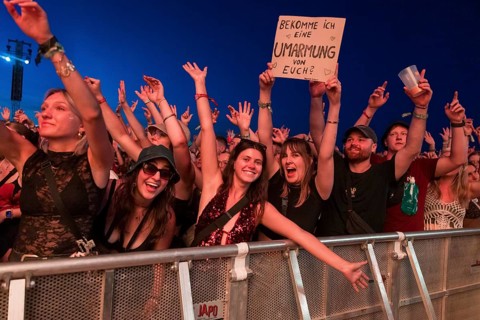 Festival goers with sign Do I get a hug from you with the band BHZ at the Highfield Festival on