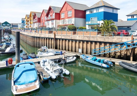 Boats at moorings, modern residential housing development at Exmouth Quay marina, Exmouth, Devon,
