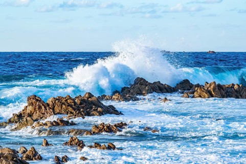 Braking waves at the coastline of Marinedda Coast at sunset, Sardinia, Italy
