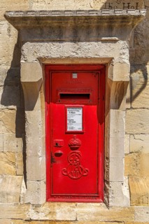 A bright red wall mounted post box bears the royal cypher of King Edward VII, who reigned from 1901