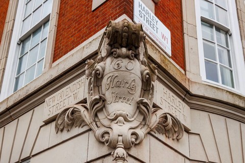 An Edwardian carved stone cartouche names Harley Street at its junction with New Cavendish Street