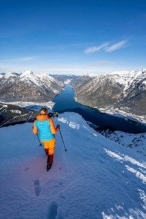 View of Achensee and wintry mountain scenery, ski tourer at the summit of Bärenkopf, Achensee,