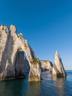 Aerial view of the Porte d'Aval rock formation with the free-standing Aiguille d'Étretat rock pin