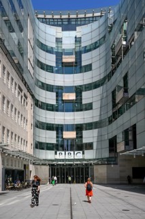 Entrance area of the BBC Broadcasting House with the distinctive curved glass façade and the BBC