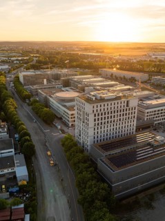 Building and street in an urban area at sunset, lined with trees, new hospital building, Böblingen