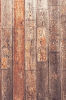 A close-up view of rustic wooden planks with varying shades of brown and gray. The texture shows