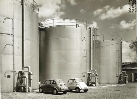BMW Isetta, Fiat 500, small cars, gas tanks, large industrial tanks with two parked retro cars and