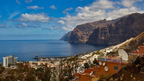 Los Gigantes, Puerto de Santiago, coastal view with village and distinctive cliffs, blue sky and