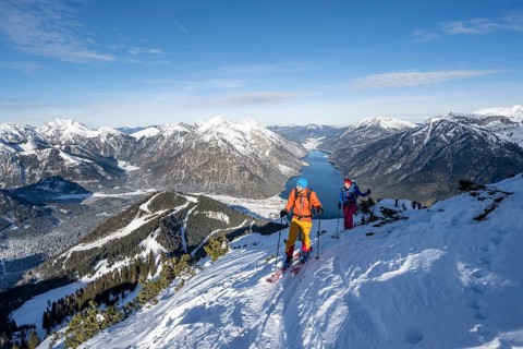 View of Achensee and wintry mountain scenery, ski tourers climbing to Bärenkopf, Achensee, Tyrol,
