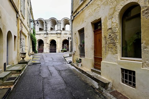 Side alleyway with view of the Roman Amphitheatre, Arles, Southern France, France