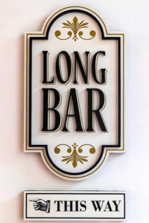 Decorative signboard directs guests to the Long Bar birthplace of the Singapore Sling cocktail,