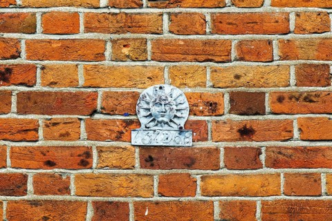 Historic Sun Fire Office fire insurance mark set into a brick wall, once identifying an insured