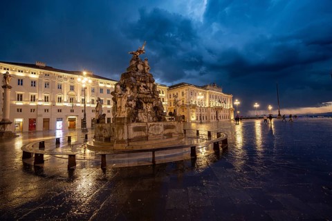 Illuminated square Piazza Unità d'Italia with Fontana dei Quattro Continenti fountain, Palazzo del