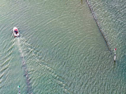 Motorboat entering the port of moss. Waves form on the surface of the water. The water level in