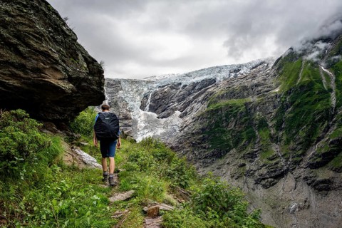 Mountaineers on a hiking trail, cloudy mountain landscape with Grindelwald-Fiescherfirn glacier,