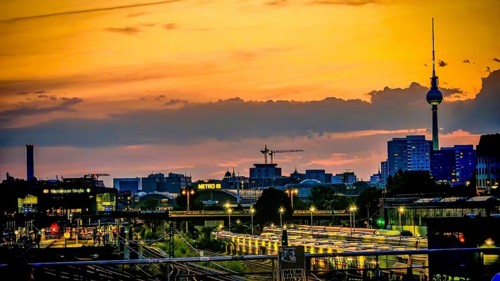 View of railway tracks from Modersohn Bridge, skyline at sunset with television tower and