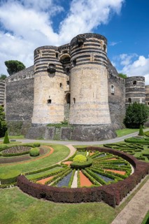Monumental castle complex from the 13th century with distinctive tower architecture, nestled in a