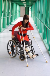 Young woman with plaster leg sitting in a wheelchair, Vienna, Austria