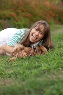 Vibrant and fun interaction between a woman and her dog in the grass