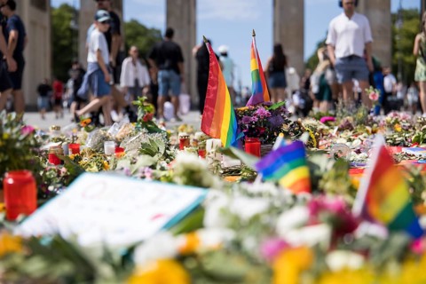 Rainbow flags in an improvised memorial made of flowers and candles on Pariser Platz in front of