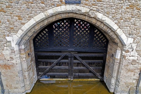 A heavy wooden lattice gate closes the arched entrance of Traitors' Gate beneath St Thomas's Tower,