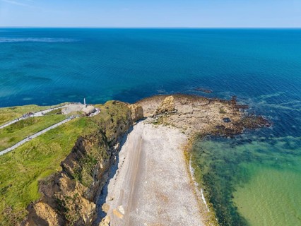 Aerial view of the historic Pointe du Hoc headland on the cliffs of Normandy. The green cliff rises