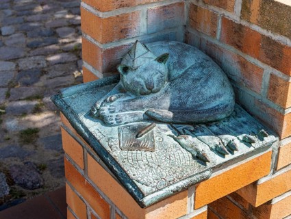 Detail of the humorous market fountain with satisfied cat, building ceramist and sculptor Christian
