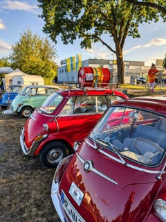 Different colored BMW Isetta park side by side, annual meeting 2026, distinctive small car with