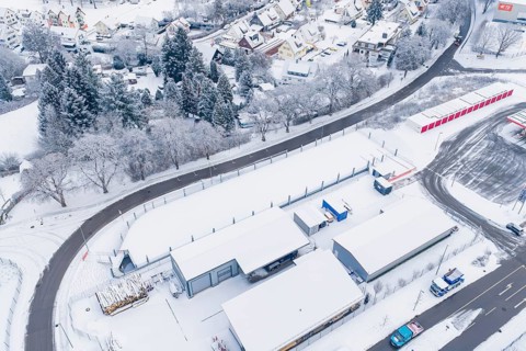 Aerial view of a snowy village and adjacent road in winter, parking garage construction, Calw,