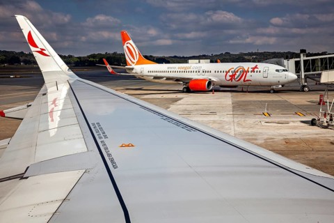 View from the plane at an airport where another aircraft is parked at the terminal, airplanes on