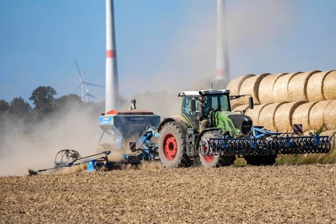 Tractor cultivates a harvested grain field, loosens the soil and then places seeds directly, with a