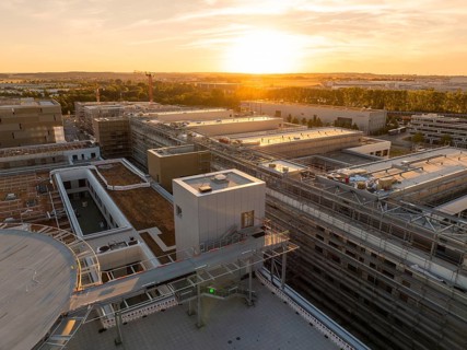 Modern building structures with crane at sunset, urban setting, construction site of the new