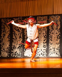 Young Thai man in traditional clothing in a historic show with knives and swords, Old Chiang Mai