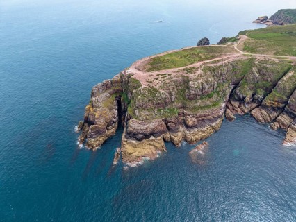 Aerial view of the rocky cliffs at Cap Fréhel with the historic Vauban lighthouse, 17th century