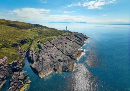 Aerial photo of the lighthouse on the rocky red cliffs of Rua Reidh point, Gairloch, Scotland, UK