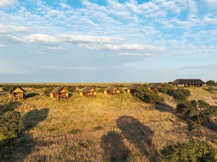 The Ta Shebube Rooiputs Lodge in the Kalahari Desert during the rainy season with green vegetation.