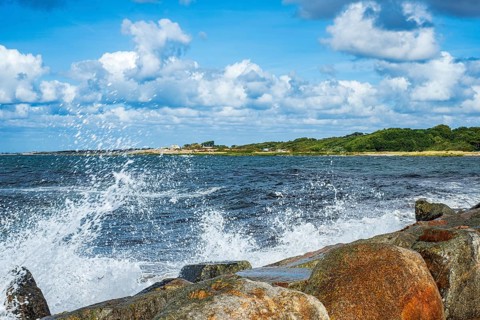 Spray from burning waves splashes across the stone crown of the Torekov pier, Skåne, Sweden. Spray