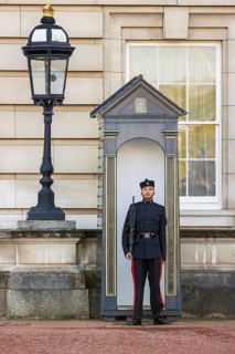 A Queen's Gurkha Signals guardsman stands sentry beside an ornate lamp post at Buckingham Palace,