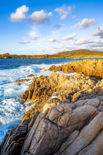 Landscape of the coastline with blue water at Marinedda Coast at sunset, Sardinia, Italy