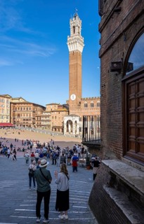 Tourists, sights and restaurants on the famous Piazza del Campo, Siena, Tuscany, Italy