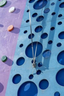 Tackling a colorful tall climbing wall tower. The setting offers a fun and engaging outdoor