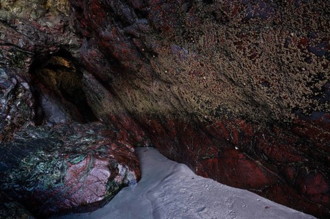 Wet rock in cave glows in various colors, coast, rock formations, rocks, sandy beach, beach,