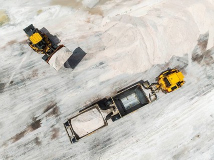 Excavator and lorry at a harvesting pan of the Walvis Bay Salt works. Aerial view. Drone shot.