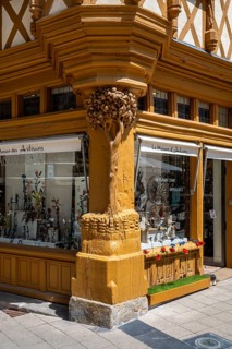 Detailed view of the medieval Maison d'Adam with historic half-timbering, large shop windows and