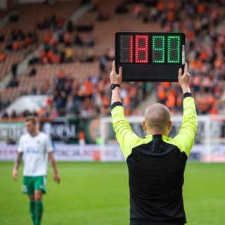 Team manager man shows players substitution during football match in Lubin, Poland