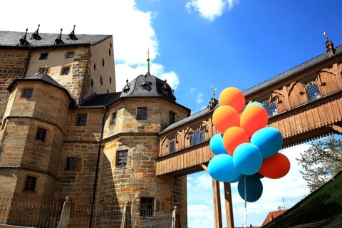 Colourful balloons in front of the transition to the castle seen from the Evangelical Lutheran St.