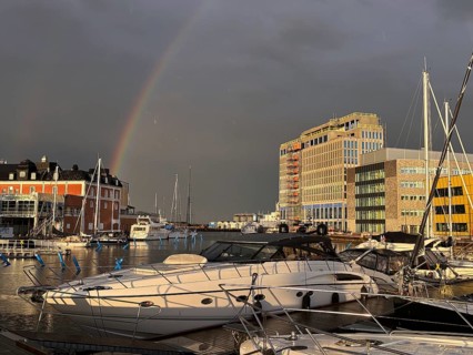 Yachts in harbor near rainbow with modern buildings in background, University, Kalmar, Kalmar Län,