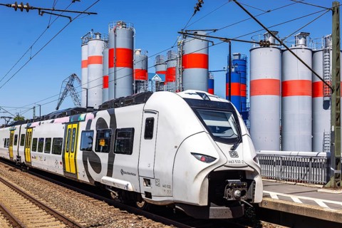 S-Bahn on the road in Mannheim. Silos from TBS Transportbeton Rhein-Neckar GmbH & Co. KG. Mannheim,