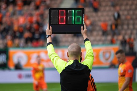 Team manager man shows players substitution during football match in Lubin, Poland
